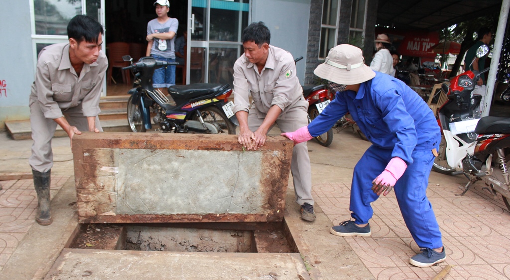 Công nhân Công ty TNHH MTV đô thị và môi trường Đắk Lắk kiểm tra cống thu nước thải trên đường Phạm Văn Đồng, TP. Buôn Ma Thuột