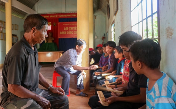 Nghệ nhân Y Nguyên Knul (ngoài cùng bên trái) cùng các nghệ nhân ở xã Ea Ktur (huyện Cư Kuin) hướng dẫn các em đánh chiêng.