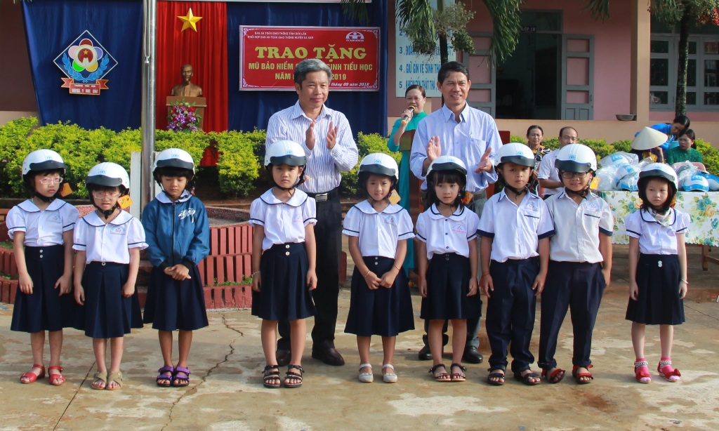 Các em Trường Tiểu học Nguyễn Thị Minh Khai (huyện Ea Kar) nhận mũ bảo hiểm.