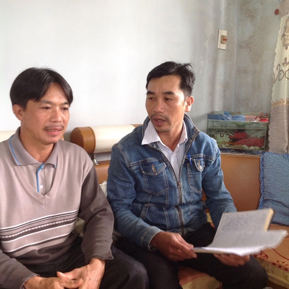 Anh Lê Văn Lặng (bên phải) tuyên truyền một số  quy định mới tại địa phương cho người dân. 