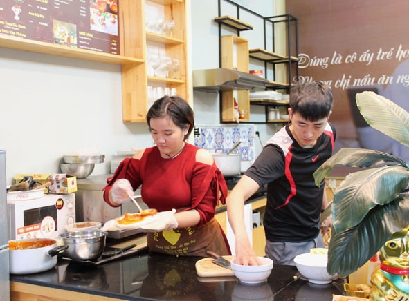 Chị Phan Thị Thu Huyền làm pizza phục vụ khách hàng tại quán Pizza Bếp Nhà của mình.  
