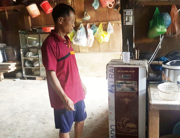 Ông Trần  Văn Tiền cùng chiếc máy lọc nước  mới mua. 