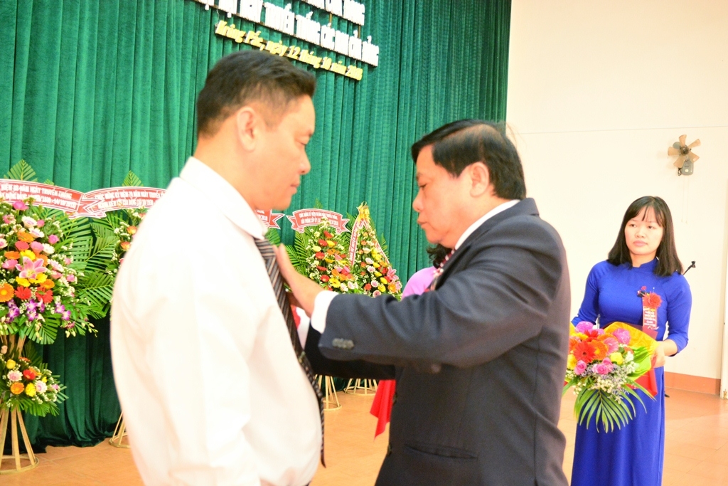 Phó Bí thư Thường trực Huyện ủy, phụ trách Đảng bộ huyện Krông Pắc Võ Túc gắn Kỷ niệm chương cho đồng chí Trần Văn Sáu.