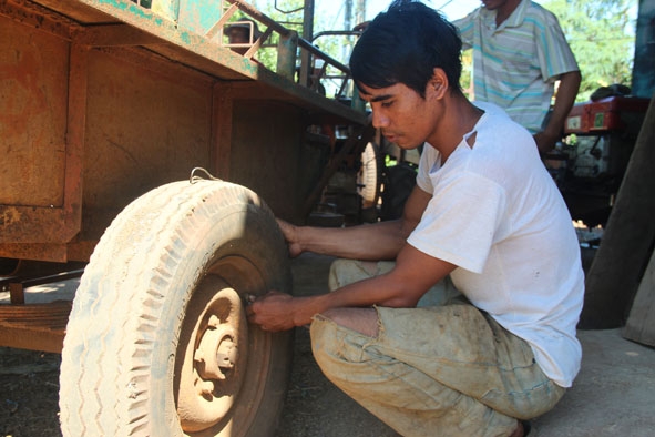 Anh Y Diu Mlô sửa chữa xe công nông cho người dân trong buôn.