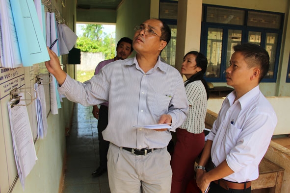 Cán bộ đoàn kiểm tra cải cách hành chính nhà nước năm 2018 kiểm tra bảng niêm yết thủ tục hành chính tại xã Ea Hiu.