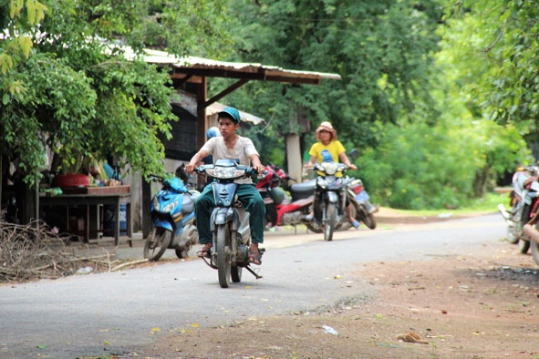 Người dân ở buôn Đrang Phốk, xã Krông Ana (huyện Buôn Đôn) không đội mũ bảo hiểm khi tham gia giao thông.