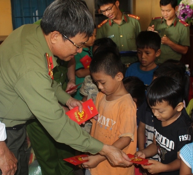 Đại diện lãnh đạo Công an tỉnh tặng bao lì xì cho các em thiếu nhi buôn Ea Mar, xã Krong Na (huyện Buôn Đôn).