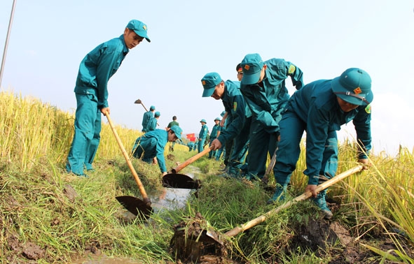 Các chiến sĩ dân quân giúp nhân dân xã Cư Êwi (huyện Cư Kuin) nạo vét kênh mương nội đồng.