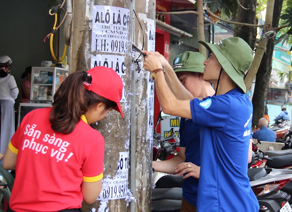 Đoàn viên thanh niên phường Thắng Lợi xóa quảng cáo, rao vặt trên đường Hai Bà Trưng. 