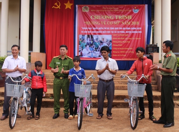 Đại diện Phòng Cảnh sát Quản lý hành chính về trật tự xã hội trao xe đạp cho học sinh nghèo hiếu học của xã Cư Pơng (huyện Krông Búk).