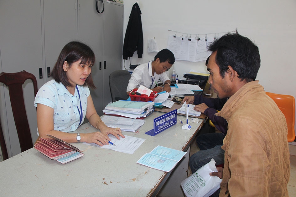 Cán bộ Văn phòng một cửa xã Ea Ktur, huyện Cư Kuin hướng dẫn người dân làm thủ tục hành chính. 