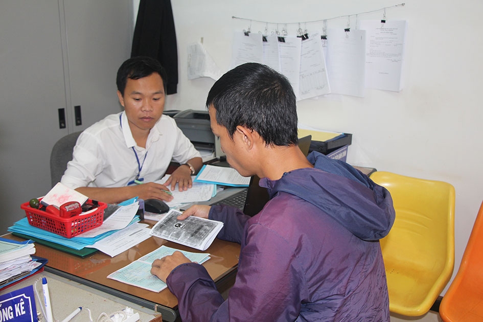 Cán bộ Văn phòng một cửa xã Ea Ktur, huyện Cư Kuin hướng dẫn người dân làm thủ tục hành chính.