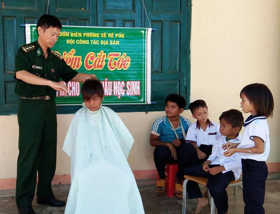 Cán bộ Đồn Biên phòng Sêrêpốk mở điểm cắt tóc miễn phí chọ học sinh và người dân buôn Đrang Phốk.