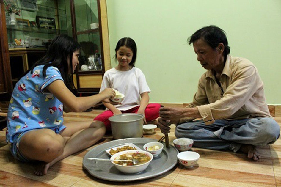 Gia đình anh Lâm Bá Sơn hạnh phúc quây quần bên mâm cơm trong ngôi nhà mới.