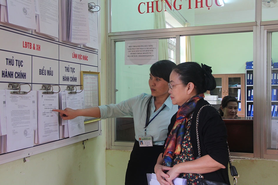 Cán bộ Bộ phận một cửa UBND phường Tân Tiến, TP. Buôn Ma Thuột hướng dẫn người dân tìm hiểu  thủ tục hành chính niêm yết công khai. 