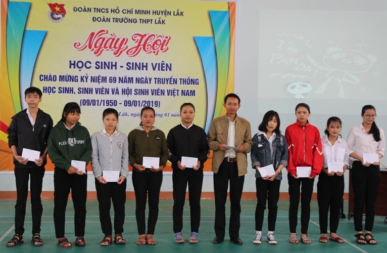đại diện lãnh đạo Trường THPT Lắk (thứ 5, từ phải sang) trao học bổng tặng các học sinh nghèo vượt khó.