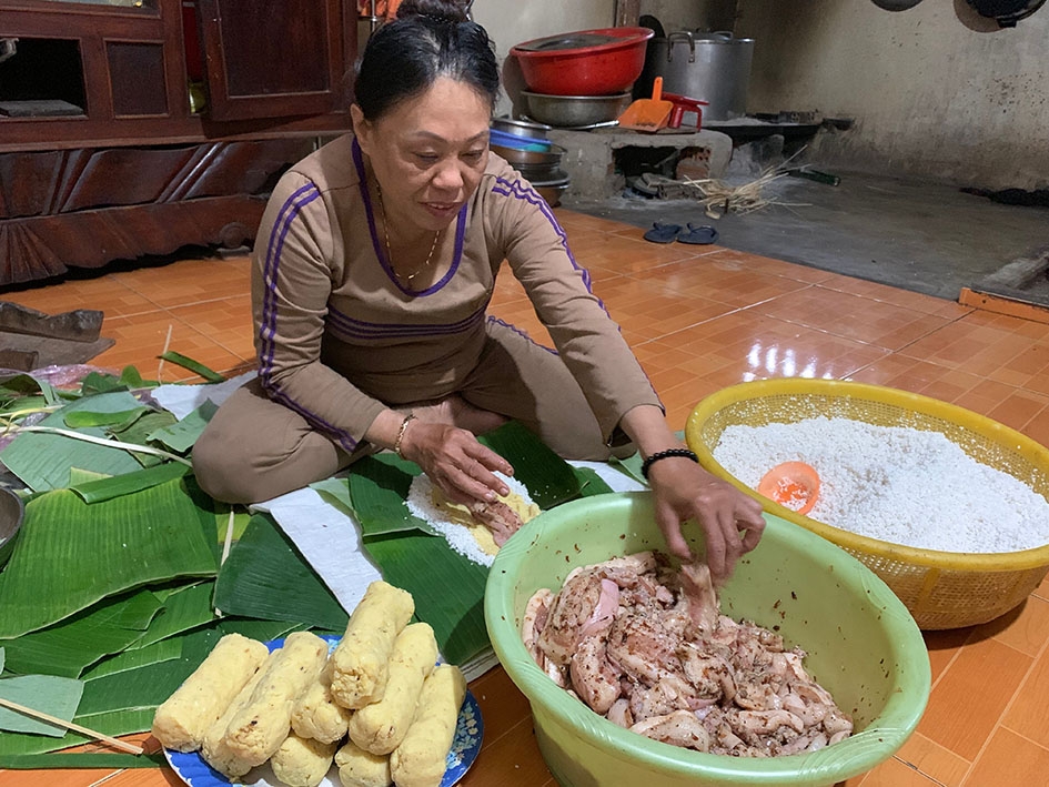 Bà Trần Thị Thu cẩn thận đặt từng nguyên liệu vào trong chiếc bánh tét. 