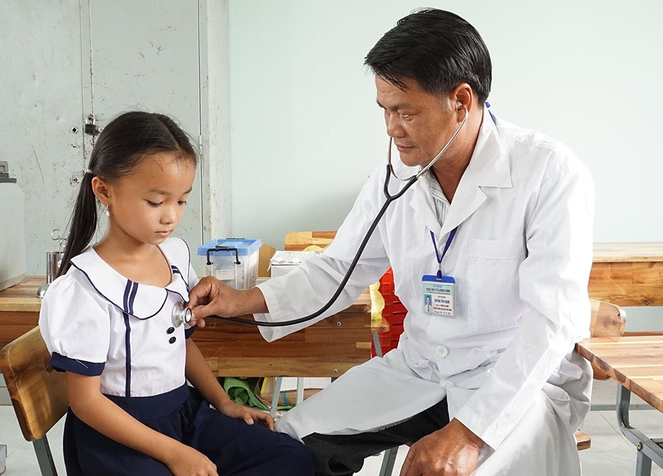 Bác sĩ Trung tâm Y tế huyện Krông Bông khám sàng lọc cho trẻ em trước khi tiêm phòng.  