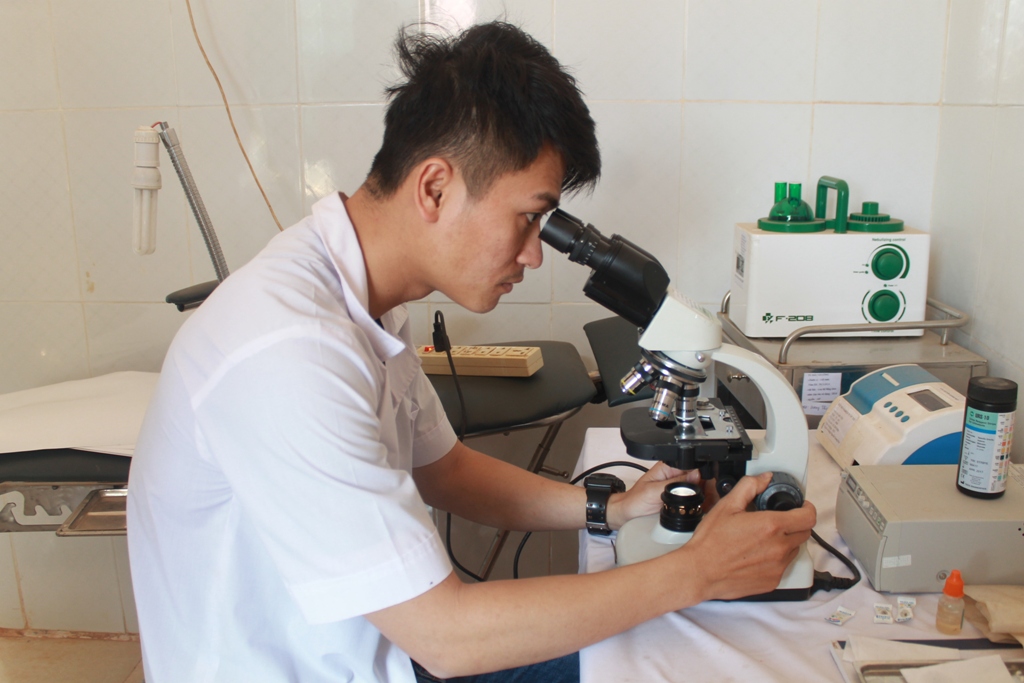 Cán bộ Trạm y tế xã Cư Huê (huyện Ea Kar) làm xét nghiệm lam máu phát hiện sốt rét trên mẫu bệnh phẩm của người bệnh. 