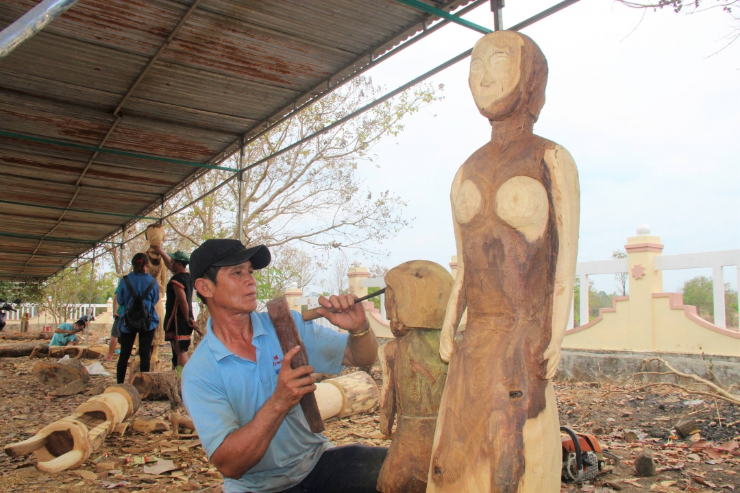 Ông Su Wat Lut (dân tộc Lào, xã Krông Na) đang hoàn tất tác phẩm tạc tượng gỗ với chủ đề “Tình mẫu tử”