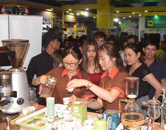 Phucj vụ cà phê miễn phí cho du khách tại gian hàng của cà phê An Thái trong khuôn khổ Hội chợ - Triển lãm