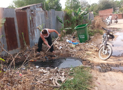 Nước thải từ trang trại chăn nuôi của gia đình ông Nguyễn Văn Mừng tràn ra đường. 