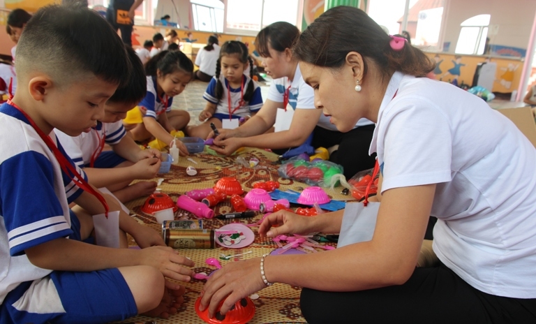 Các giáo viên và trẻ của Phòng GD-ĐT huyện Cư MGar làm đồ dùng đồ chơi tại hội thi.