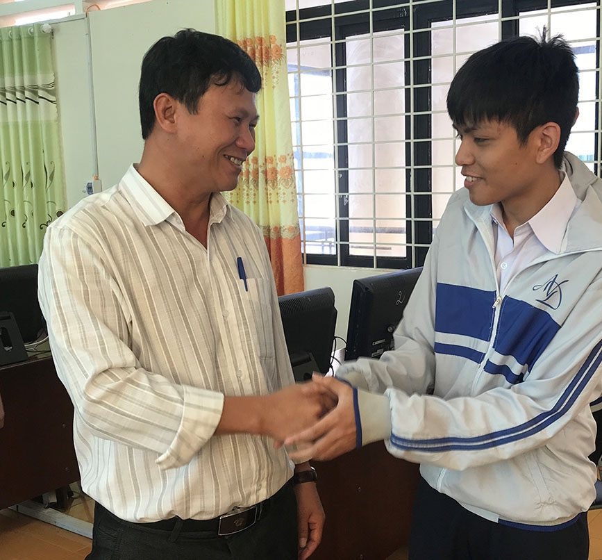 hầy giáo Nguyễn Đăng Bồng, Hiệu trưởng Trường THPT Chuyên Nguyễn Du chúc mừng thành tích đặc biệt của em Trần Thế Phong.