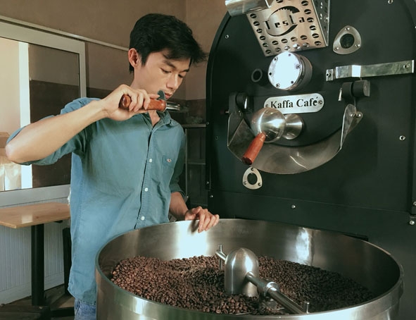 Anh Việt kiểm tra chất lượng cà phê sau khi rang. Ảnh: Nhân vật cung cấp
