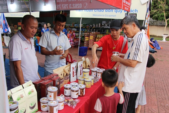 Người dân tham quan, tìm hiểu về các sản phẩm nông sản tại một gian hàng ở Phiên chợ hàng Việt  về miền núi tại huyện Krông Pắc.