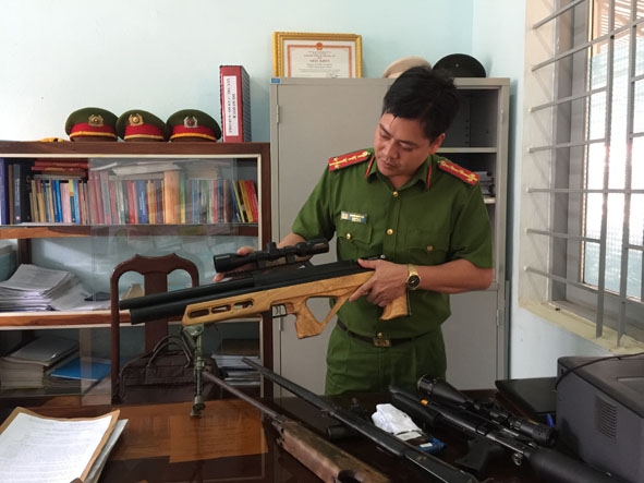 Cán bộ Công an huyện Cư M'gar kiểm tra súng tự chế thu giữ được. 