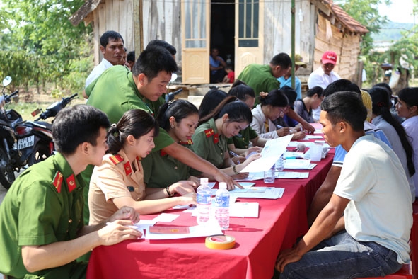 Cán bộ chiến sĩ Công an huyện Krông Ana hướng dẫn nhân dân kê khai thủ tục làm CMND.  