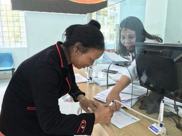 Cán bộ Phòng giao dịch Agribank Ea Ô (huyện Ea Kar) hướng dẫn khách hàng làm thủ tục vay vốn.   