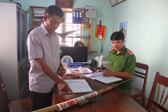 Ông Phan Văn Hạnh ở thôn 8 (bên trái) trình báo một vụ việc với Công an xã.   