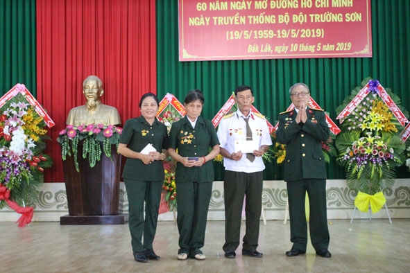Đại tá Lê Xuân Bá (bên phải) trao sổ tiết kiệm tặng các hội viên có hoàn cảnh khó khăn.  