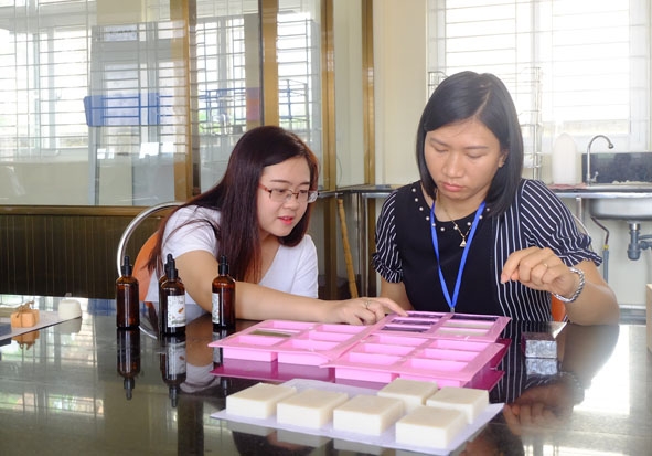 Hoàng Thị Thơm (bên trái) cùng với giảng viên Trường Đại học Tây Nguyên nghiên cứu và thử nghiệm những dòng sản phẩm mới từ tinh dầu. 