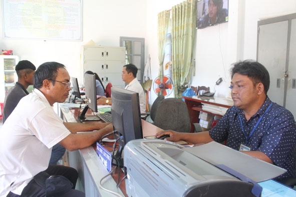Cán bộ, công chức Bộ phận tiếp nhận và trả kết quả - UBND xã Ea Drơng (huyện Cư M'gar) giải quyết hồ sơ thủ tục hành chính cho người dân. 