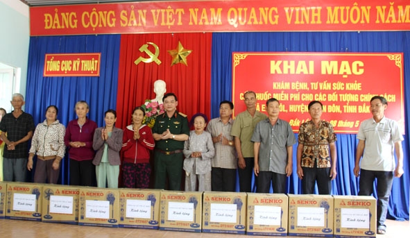 Thiếu tướng Trần Duy Hưng và đại diện lãnh đạo huyện Buôn Đôn trao quà tặng các gia đình chính sách.