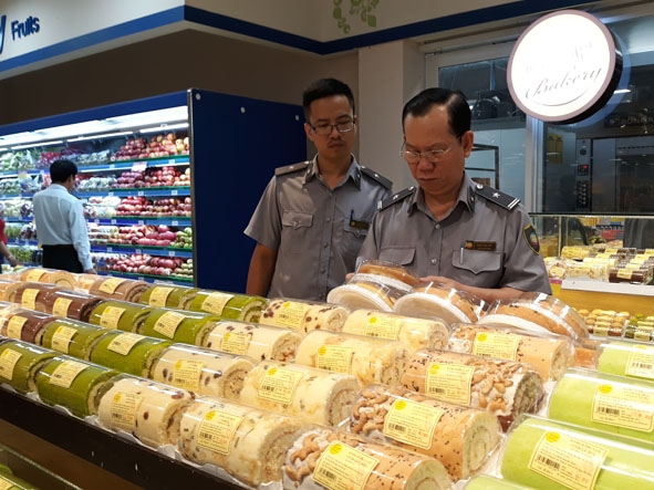 Lực lượng chức năng kiểm tra  thực phẩm  tại một  cửa hàng. 