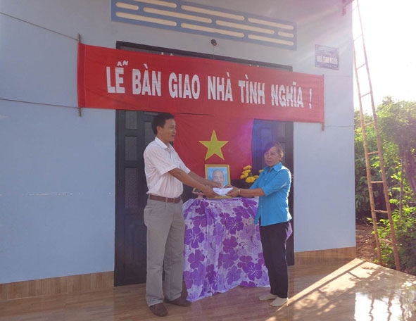 Bà Dương Thị Mai nhận quà của Hội Cựu chiến binh thị trấn Quảng Phú tặng trong lễ bàn giao nhà.