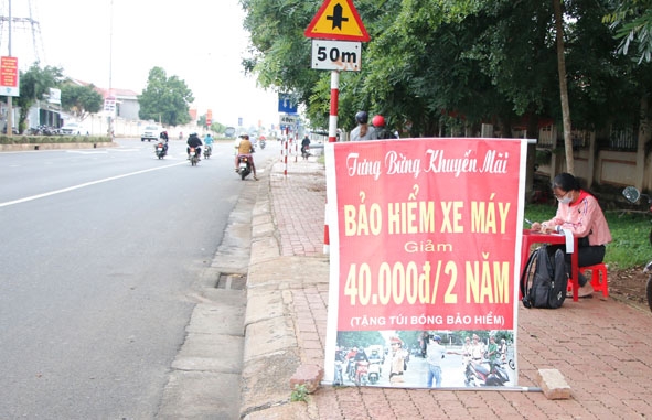Banner quảng cáo khuyến mãi hấp dẫn của một điểm bán bảo hiểm xe máy trên đường Lê Duẩn,  TP. Buôn Ma Thuột.