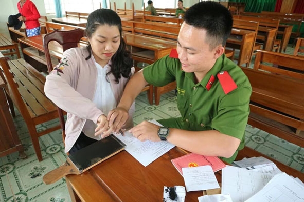 Chiến sĩ Công an huyện Krông Bông hỗ trợ người dân làm chứng minh nhân dân.  