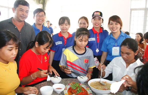 Anh Hồ Quốc Nam (ngoài cùng bên trái) và các tình nguyện viên chụp ảnh với thí sinh tại nhà ăn.