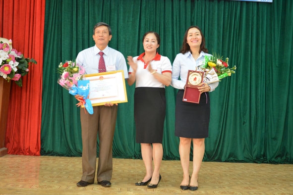 Chủ tịch Hội Chữ thập đỏ huyện Krông Pắc Tô Minh Lợi (ảnh trái) nhận Bằng khen của Trung ương Hội Chữ thập đỏ trao cho huyện hội vì đã có thành tích xuất sắc trong các mặt công tác.