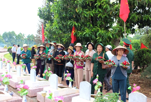 Bà Mạc (thứ 2, bên phải) cùng các thành viên trong nhóm chuẩn bị hoa tươi đặt lên các phần mộ liệt sỹ.