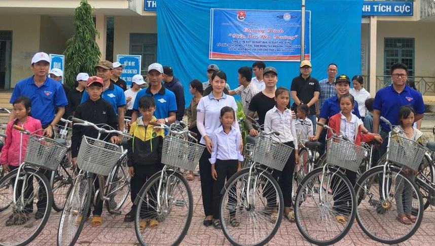 Các em học sinh nhận xe đạp từ chương trình.