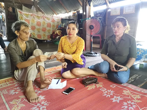 Bà Nguyễn Thị Linh  trao số tiền vận động được để  hỗ trợ  ông Y Nha Niê  chữa bệnh.  