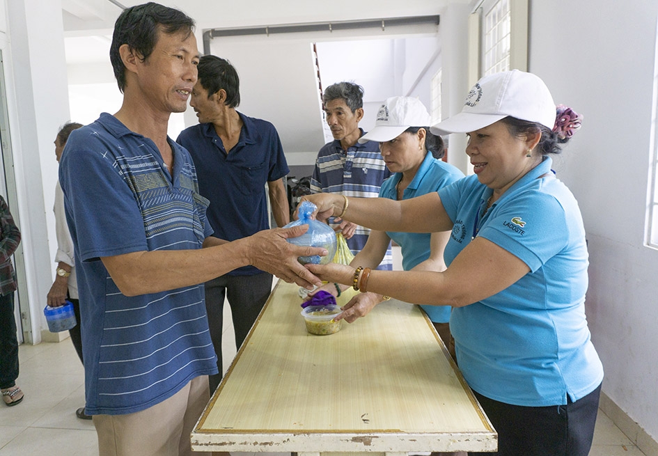 Bà Phạm Thị Mai trao suất cháo từ thiện cho người nhà bệnh nhân đang điều trị tại Bệnh viện Đa khoa vùng Tây Nguyên. 