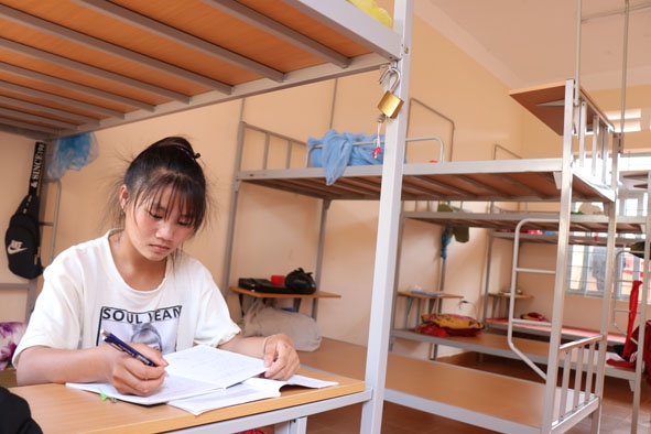 Em Ma Thị Thu, học sinh lớp 9A3, Trường THCS Cư Pui học bài trong ký túc xá của trường. 