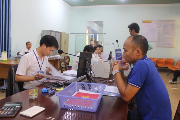 Cán bộ, công chức Bộ phận tiếp nhận và trả kết quả - UBND huyện Cư M'gar giải quyết hồ sơ thủ tục hành chính  cho người dân. 